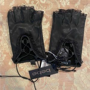 Bebe black lather fingerless gloves with fringed trim. NWT size M/L